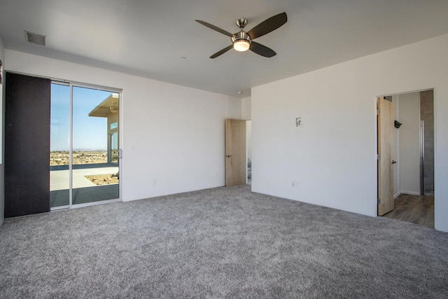 unfurnished bedroom featuring ceiling fan, access to exterior, and dark carpet