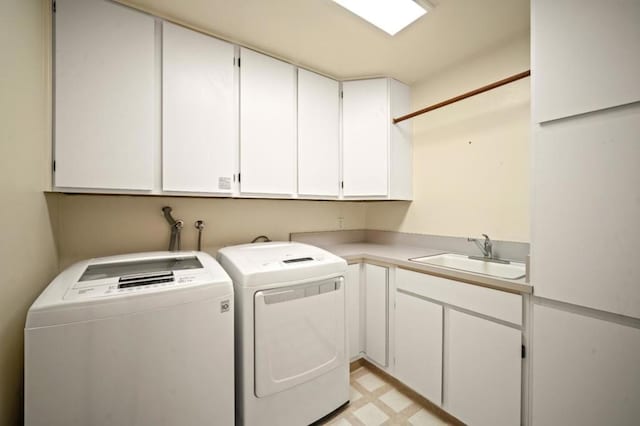 washroom with cabinets, washer and clothes dryer, and sink