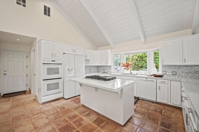 kitchen with white cabinetry, sink, high vaulted ceiling, white appliances, and decorative backsplash