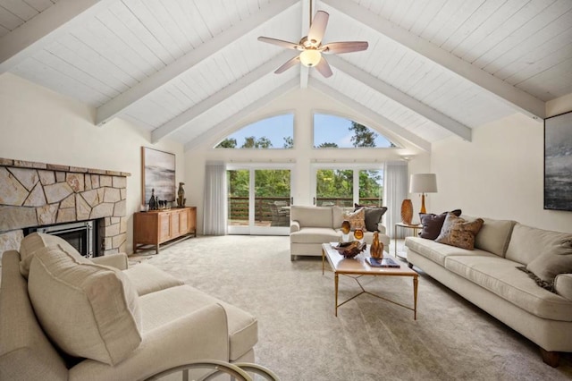 carpeted living room featuring beam ceiling, high vaulted ceiling, a stone fireplace, and ceiling fan