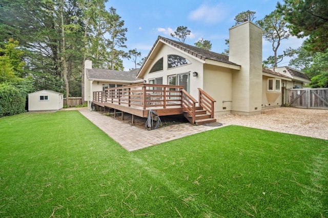 rear view of house featuring a patio, a yard, a deck, and a storage shed