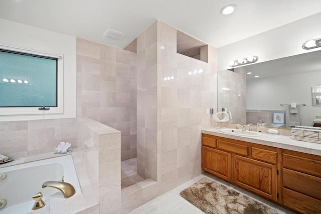 bathroom with separate shower and tub, tile patterned flooring, vanity, and tile walls