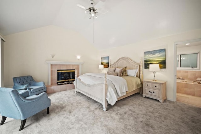 carpeted bedroom featuring ceiling fan, lofted ceiling, a fireplace, and connected bathroom