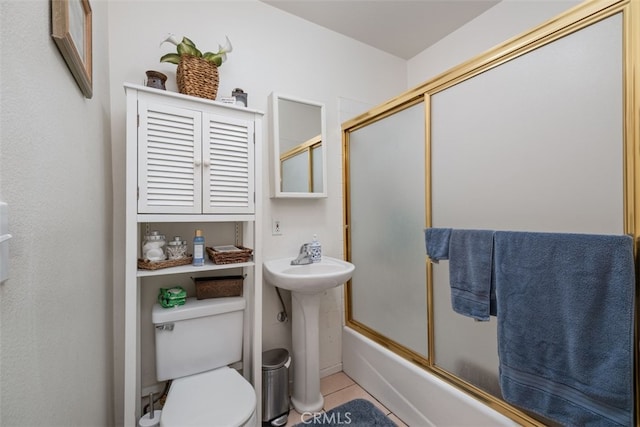 full bathroom featuring sink, combined bath / shower with glass door, toilet, and tile patterned flooring