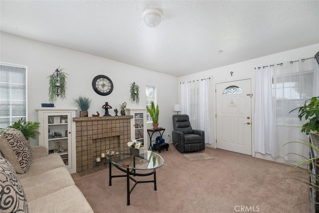 carpeted living room featuring a textured ceiling and a tiled fireplace