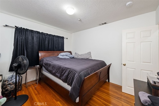 bedroom featuring dark wood-type flooring and a textured ceiling