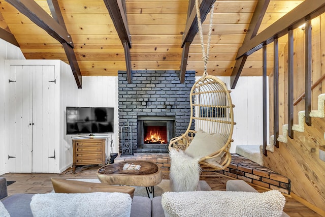 living room with wood ceiling, a brick fireplace, vaulted ceiling with beams, and wood walls