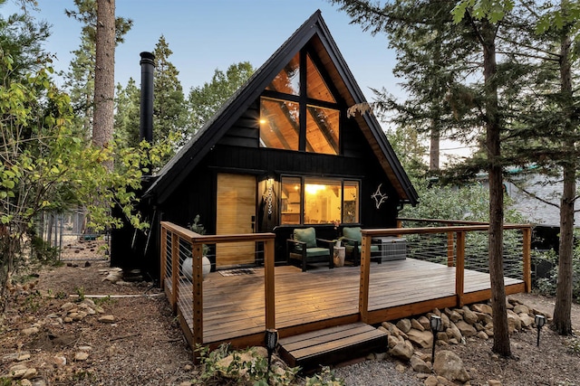 rear view of property with a wooden deck and central AC