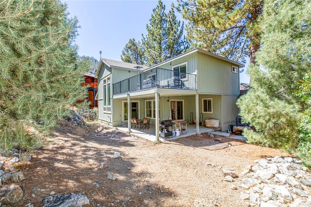 rear view of property featuring a patio and a deck