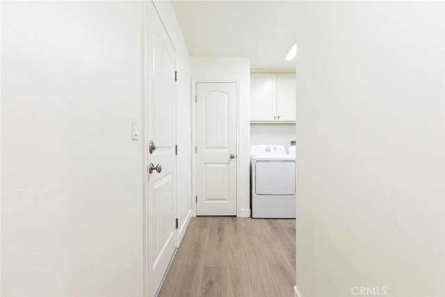 laundry area with cabinets, light hardwood / wood-style floors, and washing machine and dryer