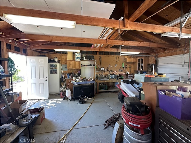 garage featuring a workshop area and wood walls