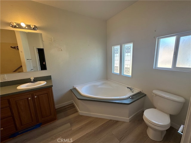 bathroom featuring a bathtub, toilet, hardwood / wood-style floors, lofted ceiling, and vanity