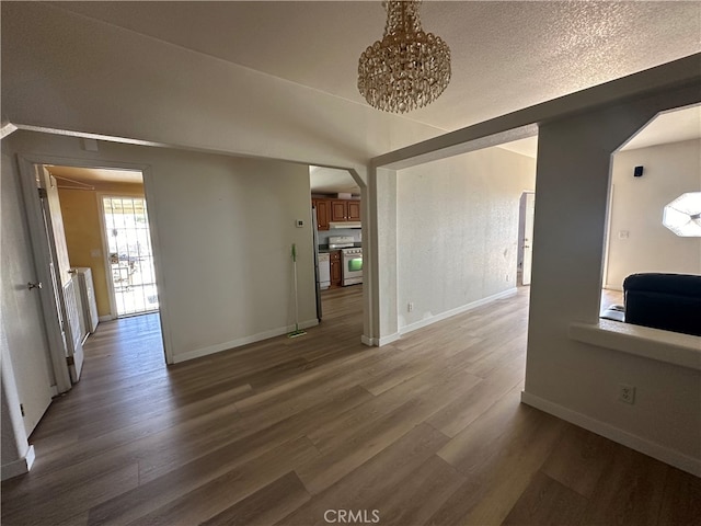 unfurnished living room with lofted ceiling, hardwood / wood-style floors, and a textured ceiling