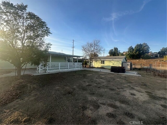 view of yard featuring a porch, a patio, and fence