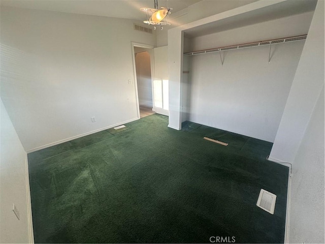 unfurnished bedroom with dark colored carpet, a closet, visible vents, and baseboards