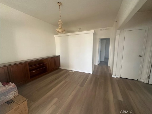 interior space with baseboards, visible vents, and dark wood-type flooring