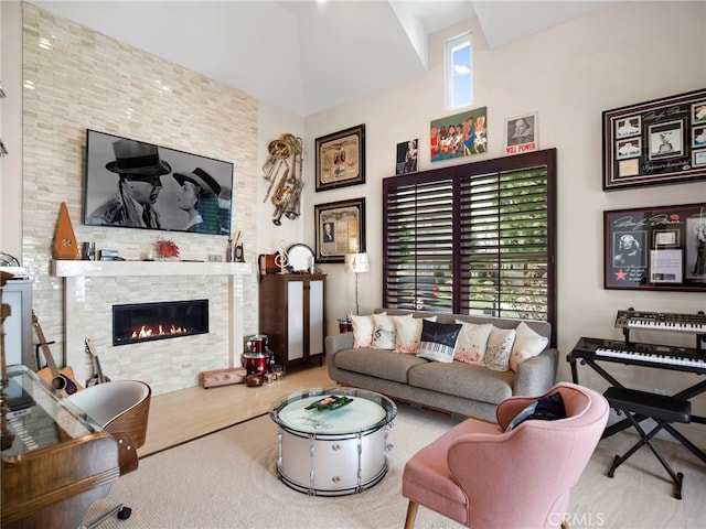 living room with a healthy amount of sunlight, a stone fireplace, and wood-type flooring