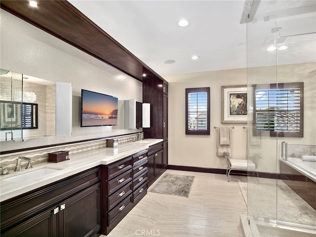 bathroom with vanity, plenty of natural light, and separate shower and tub