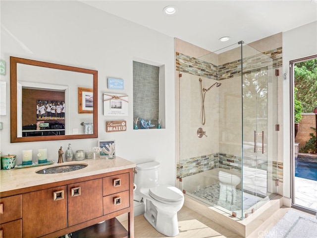 bathroom with walk in shower, vanity, and toilet