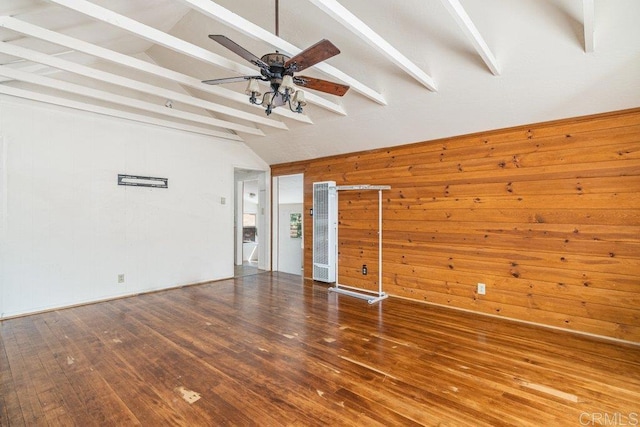 interior space with lofted ceiling with beams, wood walls, ceiling fan, and hardwood / wood-style flooring