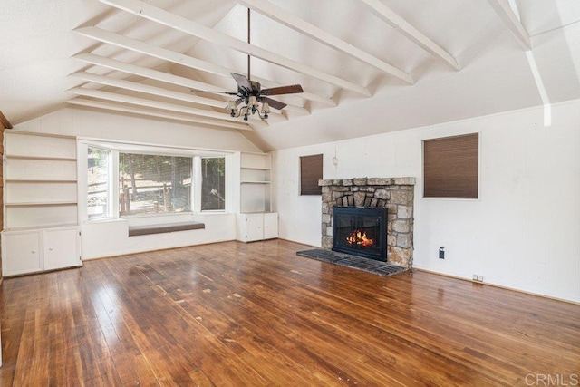 unfurnished living room with vaulted ceiling with beams, a stone fireplace, ceiling fan, and hardwood / wood-style flooring