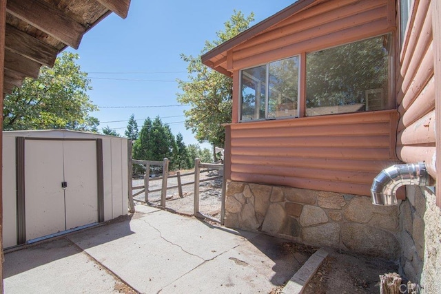 view of patio with a storage shed and a sunroom