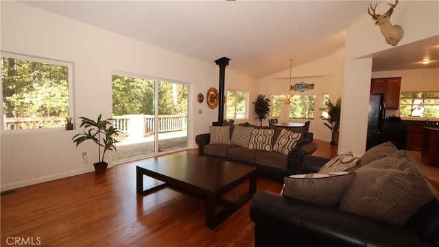 living room with a notable chandelier, lofted ceiling, and dark wood-type flooring