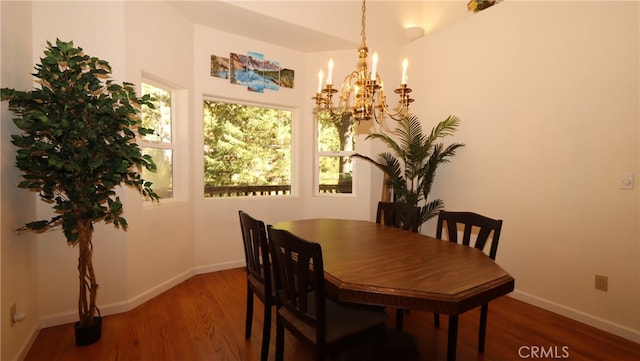 dining area with dark hardwood / wood-style floors and a chandelier