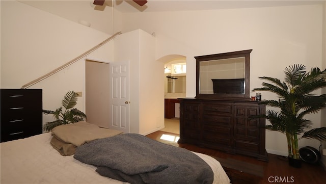 bedroom with connected bathroom, lofted ceiling, ceiling fan, and dark hardwood / wood-style flooring