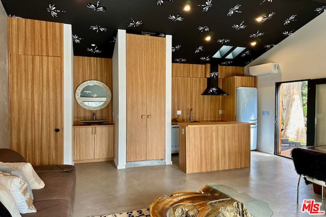 interior space featuring an AC wall unit, wooden walls, range hood, a center island, and white fridge