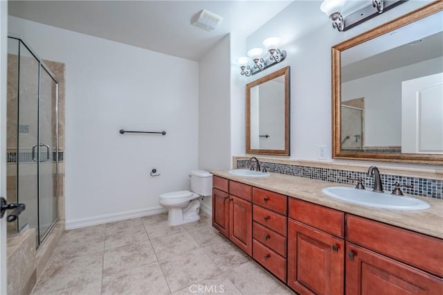 bathroom with tile patterned flooring, backsplash, toilet, a shower with door, and vanity