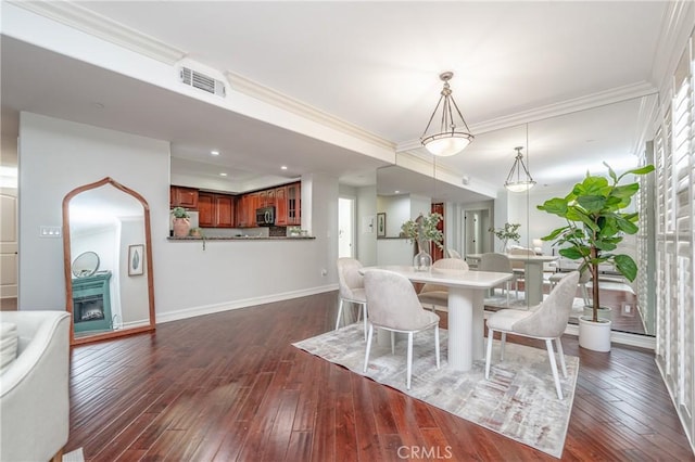 dining area featuring ornamental molding and dark wood-type flooring