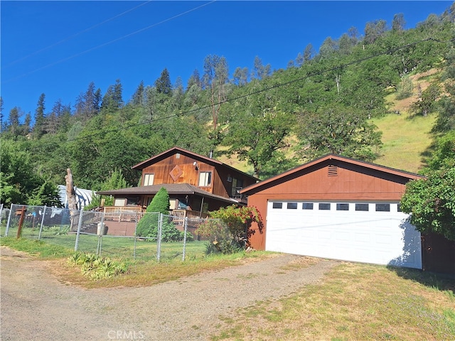 view of front of home with a garage and an outbuilding