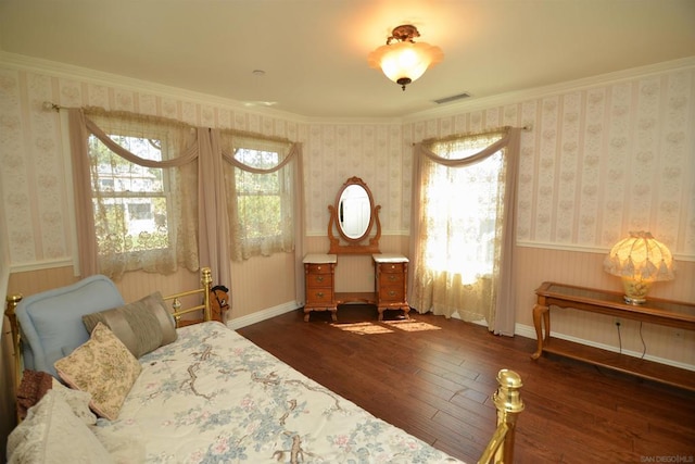 interior space with a healthy amount of sunlight, ornamental molding, and dark hardwood / wood-style flooring