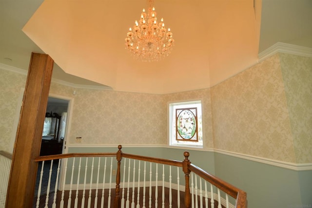 staircase with an inviting chandelier and ornamental molding