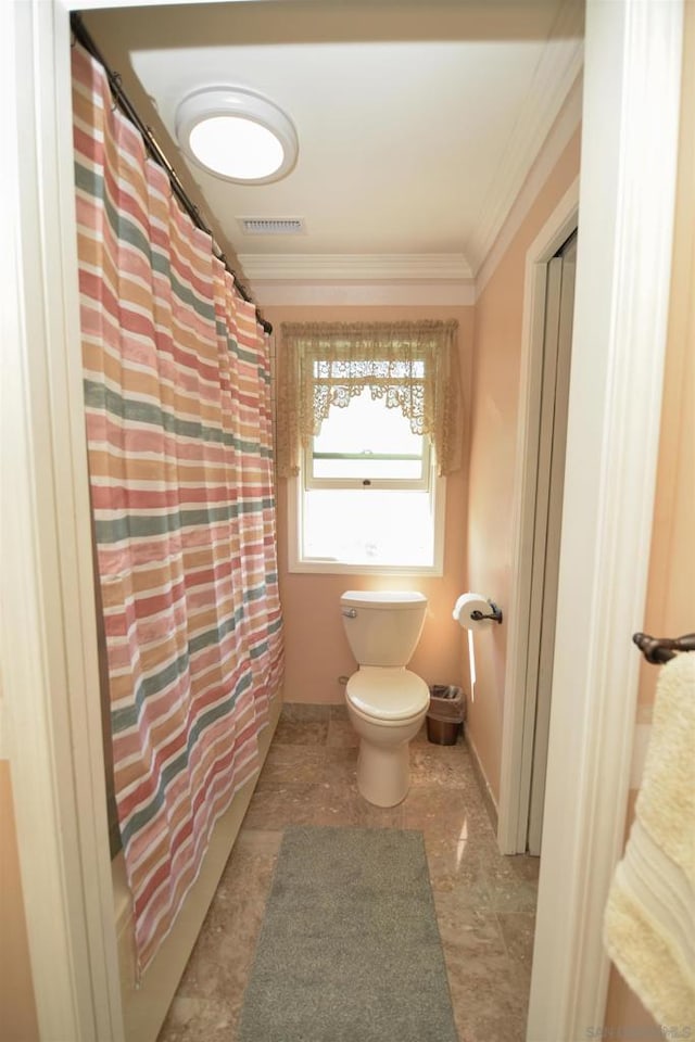 bathroom featuring ornamental molding, toilet, and curtained shower