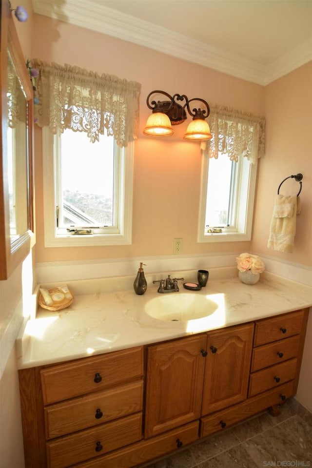 bathroom featuring a healthy amount of sunlight, tile patterned floors, vanity, and crown molding