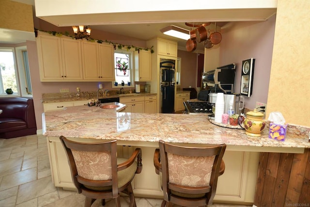 kitchen with cream cabinetry, a kitchen bar, and kitchen peninsula