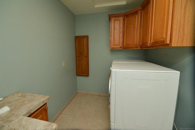 laundry area with washer / clothes dryer, light tile patterned flooring, and cabinets