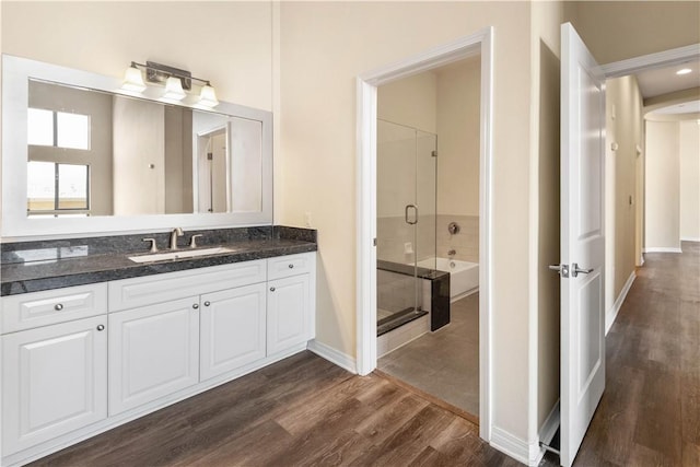 bathroom with separate shower and tub, vanity, and wood-type flooring