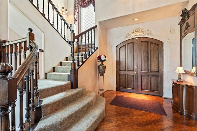 entrance foyer featuring dark wood-type flooring and a towering ceiling