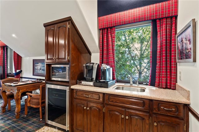 kitchen featuring stainless steel microwave, wine cooler, dark brown cabinets, vaulted ceiling, and sink