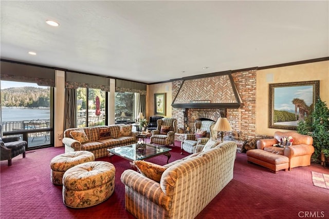 living room with a brick fireplace, crown molding, a water view, and carpet floors