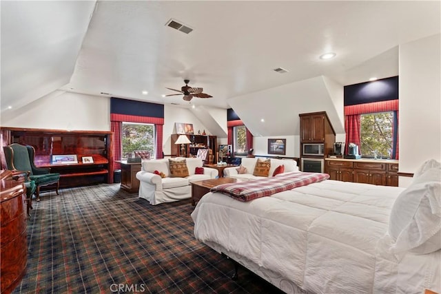 carpeted bedroom with ceiling fan, vaulted ceiling, and sink