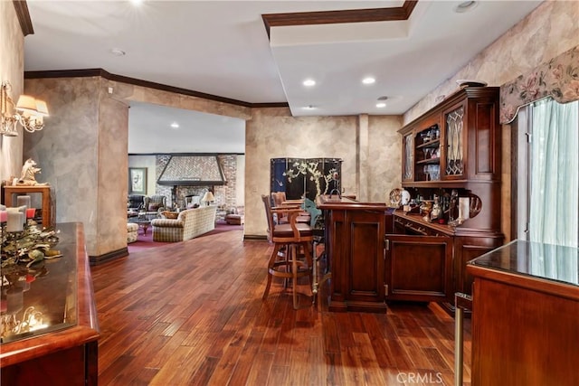 bar with dark wood-type flooring and crown molding