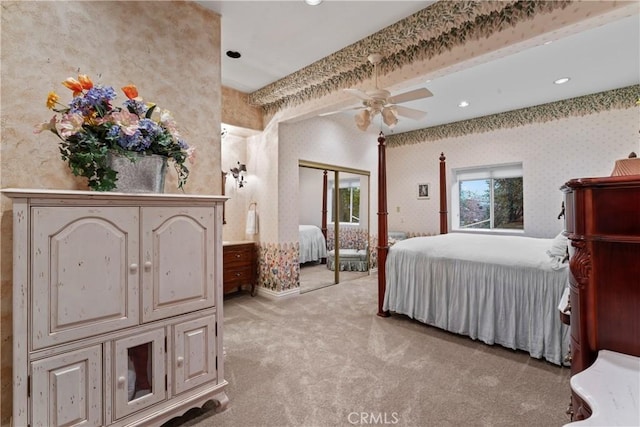 bedroom with ceiling fan, a closet, light colored carpet, and beamed ceiling