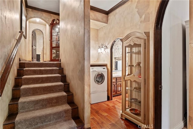 stairs featuring washer / dryer and crown molding