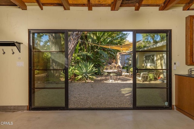 entryway featuring concrete floors and beam ceiling