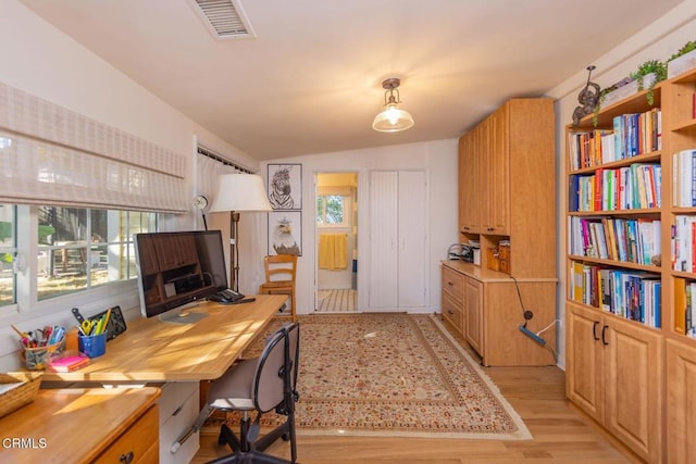 office space with vaulted ceiling and light wood finished floors