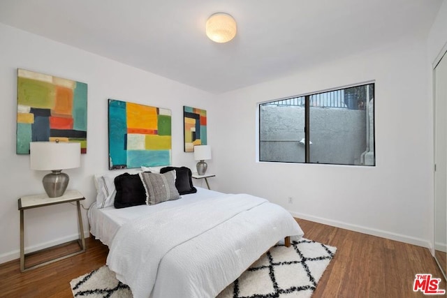 bedroom with dark wood-type flooring